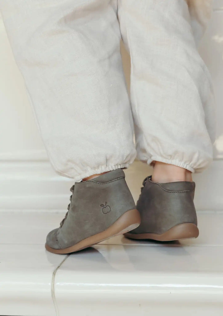 Bottines en cuir gris avec lacets et un design simple et minimaliste.