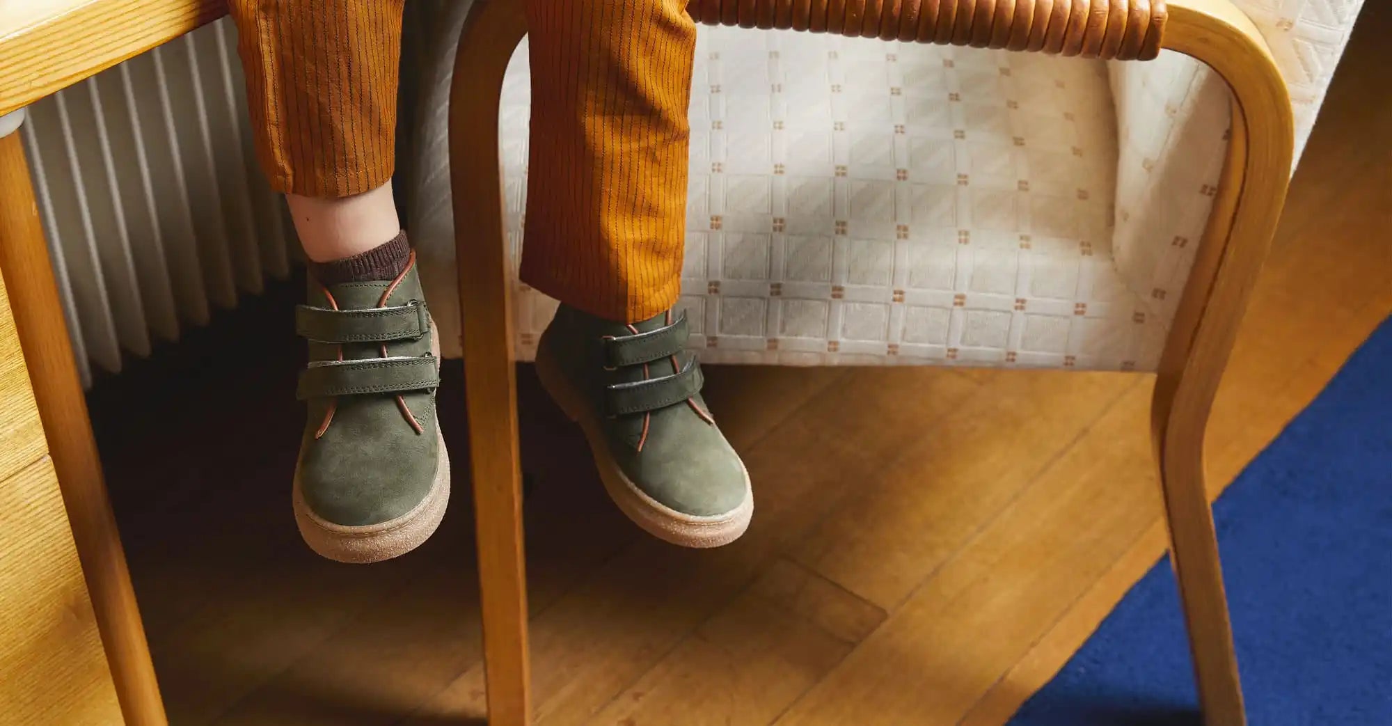 Chaussures en daim gris avec des bandes velcro portées avec des chaussettes jaune moutarde.