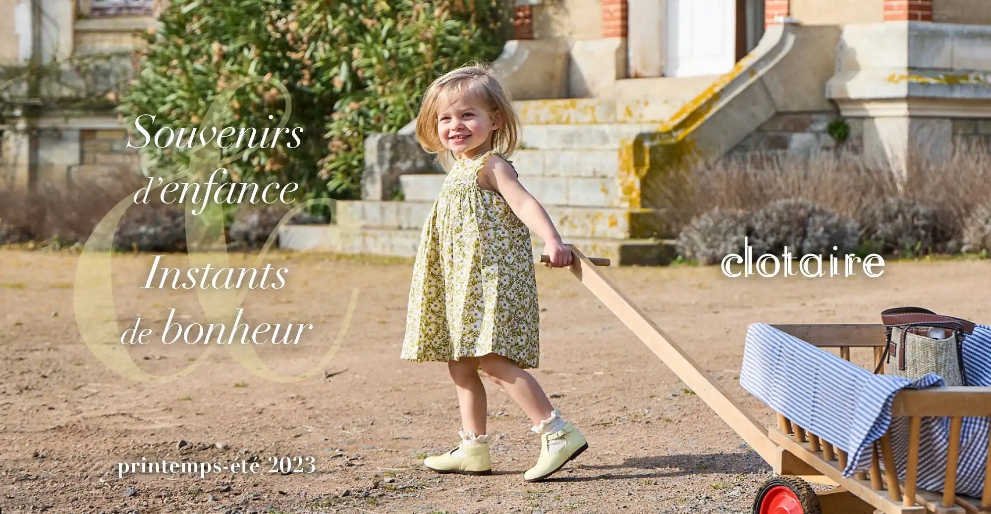 Un jeune enfant portant une robe à fleurs et des chaussures blanches.