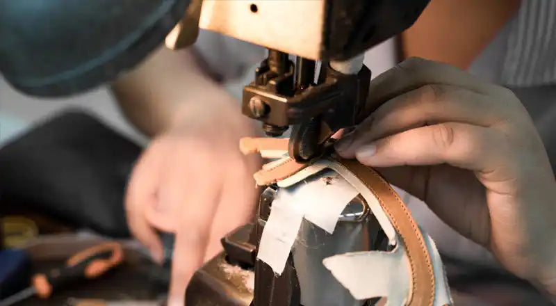 Aiguille de machine à coudre piquant à travers le matériau en cuir.