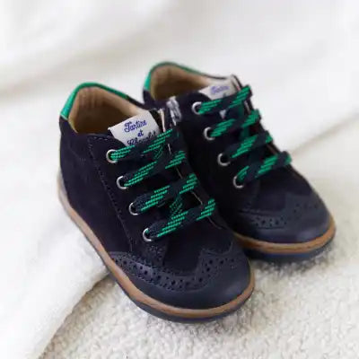 Chaussures oxford en daim bleu marine pour enfants avec des lacets verts et des détails de brogue.