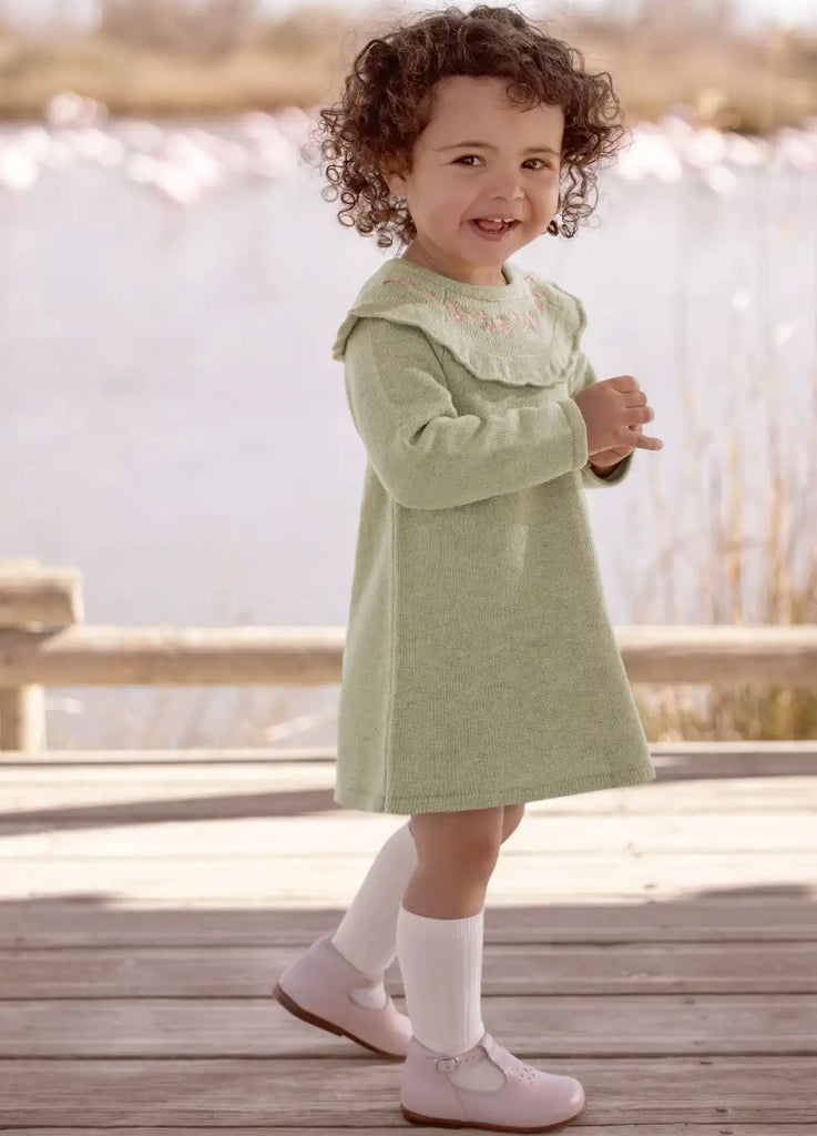 Une robe vert menthe avec un col en dentelle blanche et des chaussettes et des chaussures assorties.